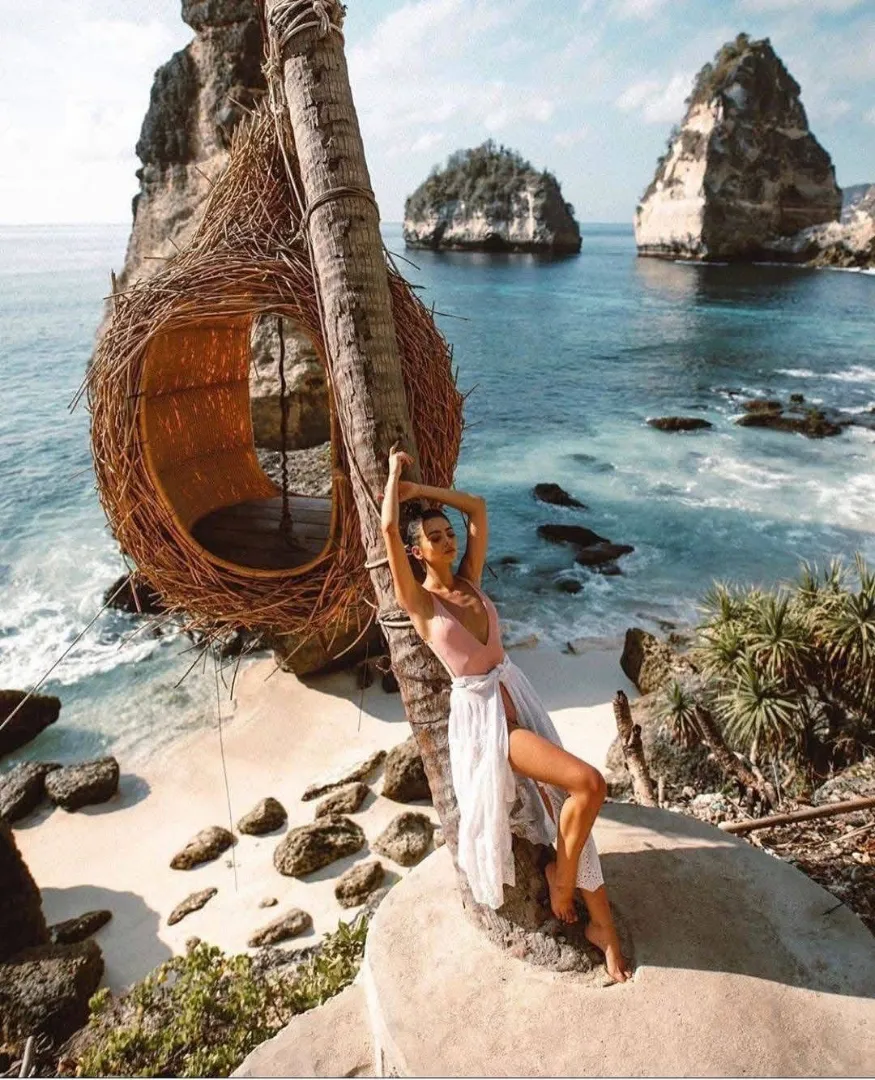 Woman relaxing at the iconic tree house nest with ocean view in Nusa Penida Bali